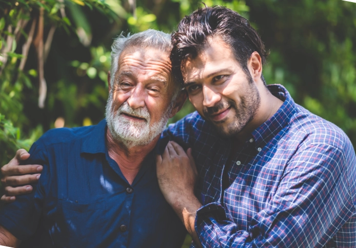 A senior man and a male smiling together