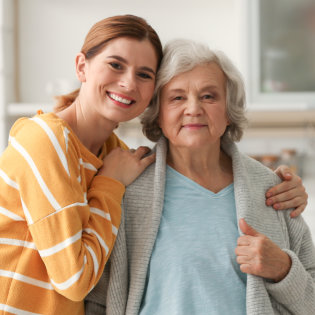 A female hugging the senior woman