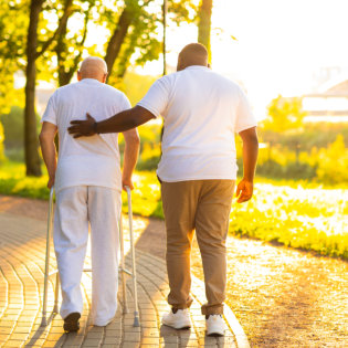 A senior man and a male walking outside