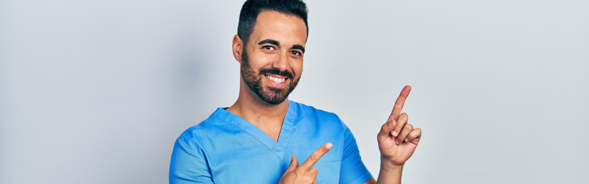 A male caregiver smiling while doing the pointy finger pose